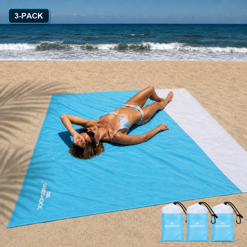 Woman relaxing on a turquoise Sandshock sandproof beach blanket with three carry bag